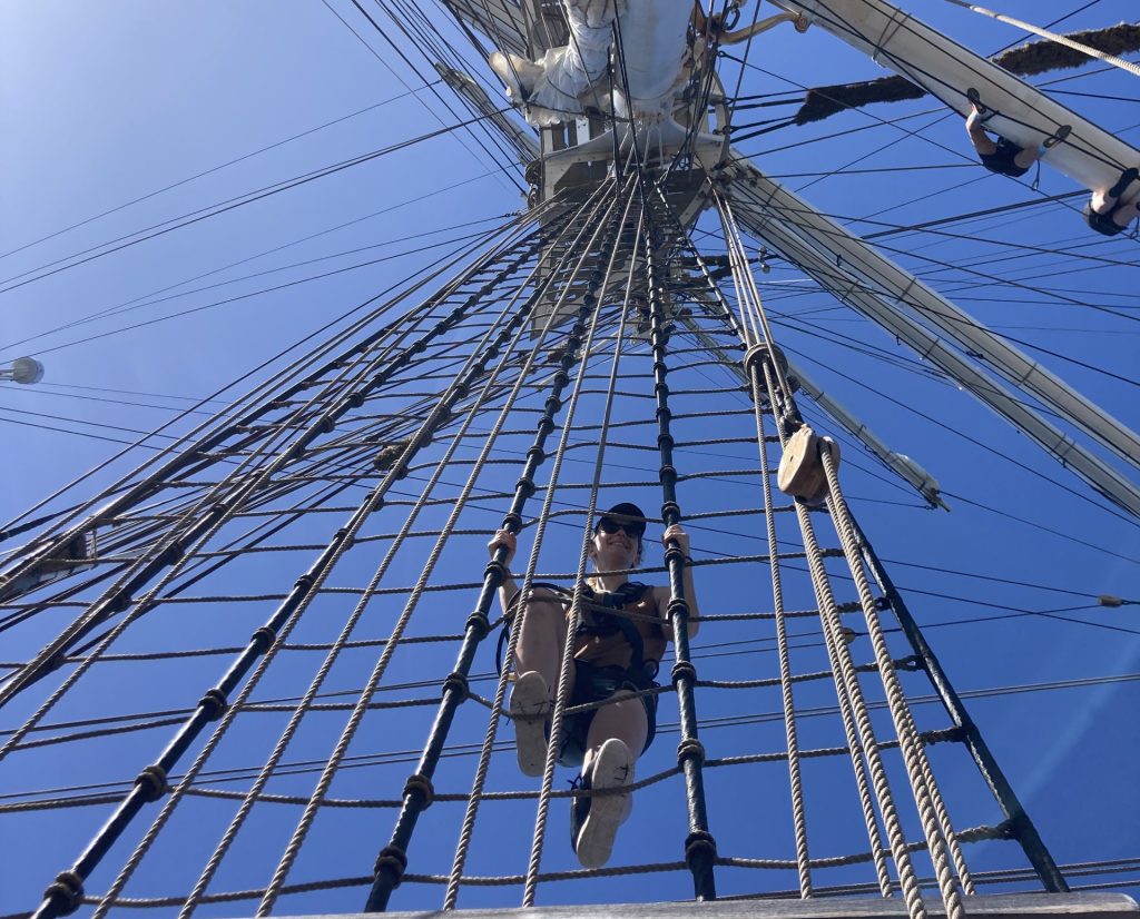 Enora Lecordier climbs the rigging on a tall ship during the One Ocean Expedition
