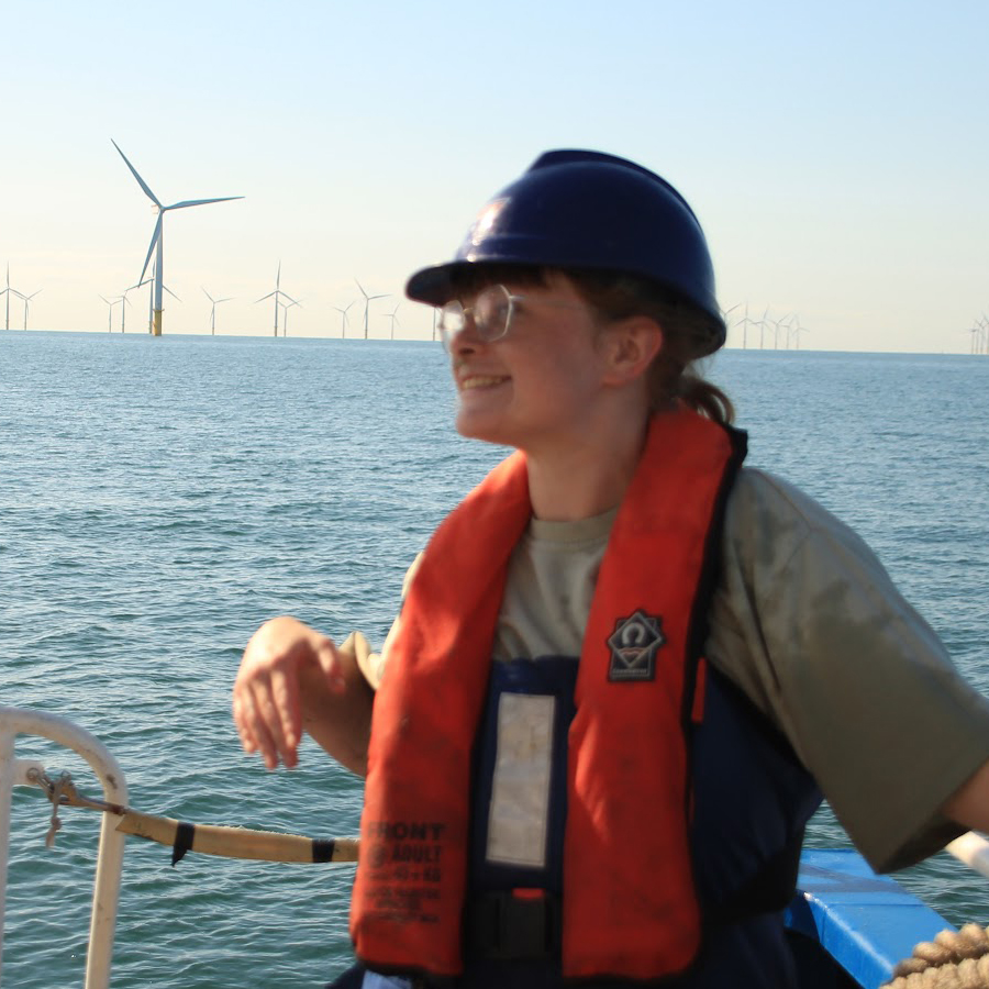 CDT student Alanna Kirwan Lambe on a boat with offshore wind turbines in the background